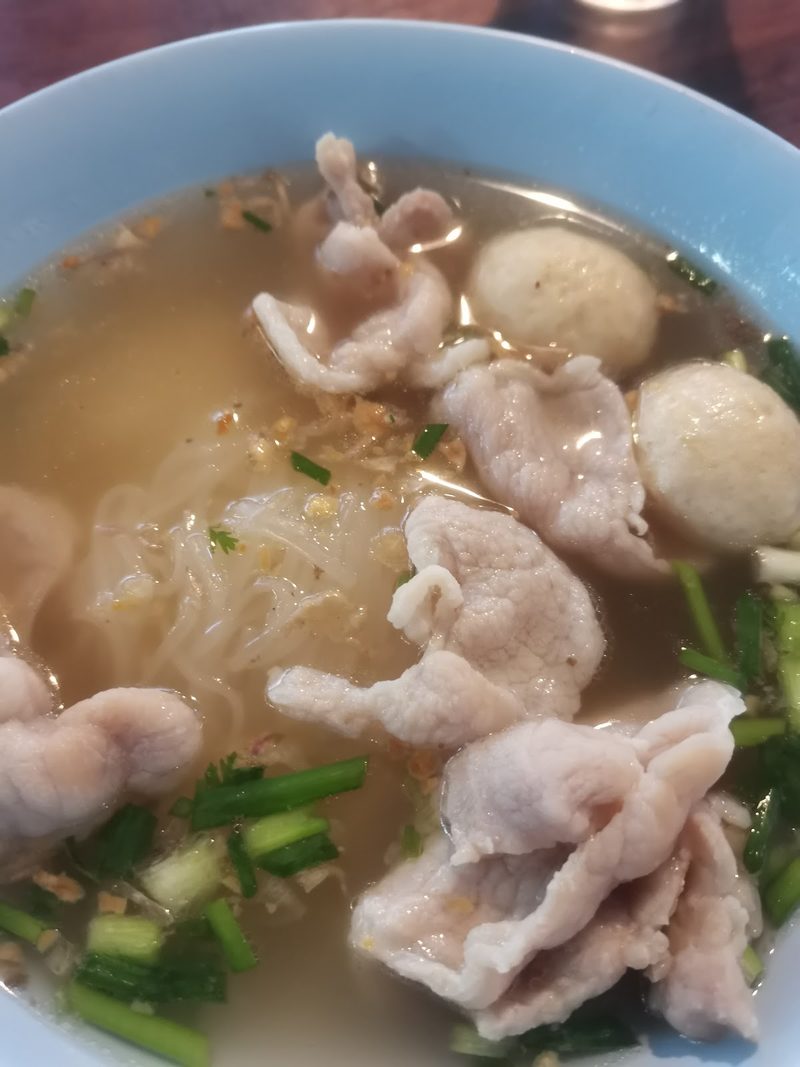 ก๋วยเตี๋ยวน้ำใสใส่หมูสไลซ์ ลูกชิ้น ผักกวางตุ้ง และต้นหอม